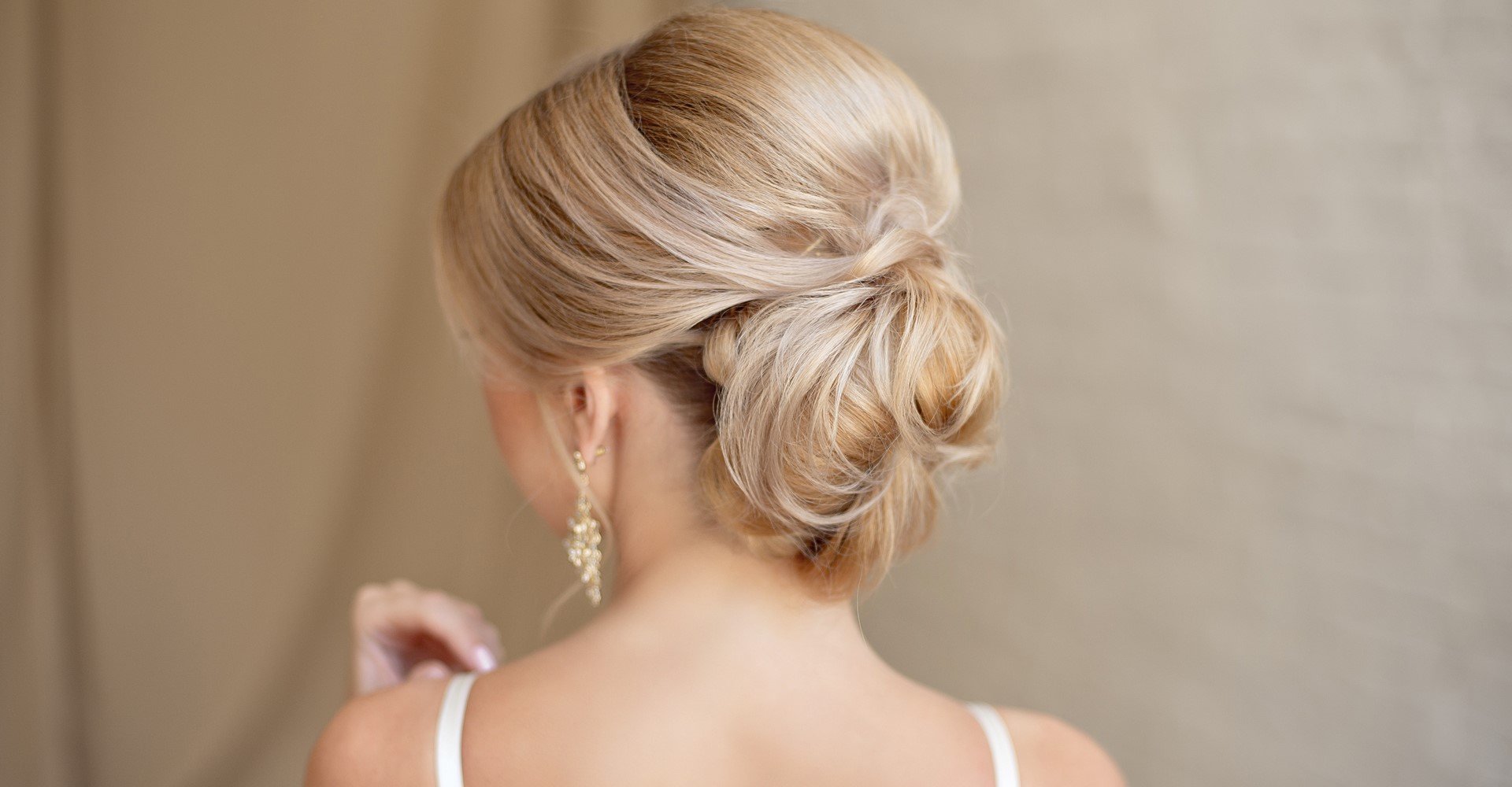 Modelo loira com coque vestida de noiva