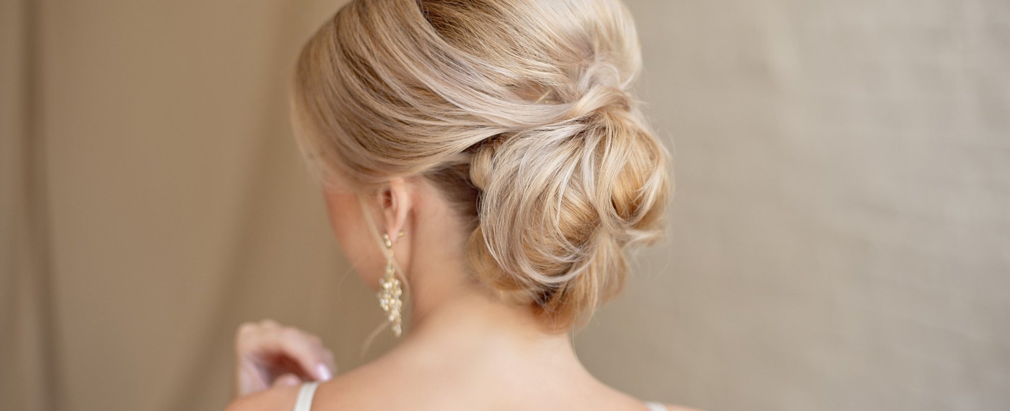 Modelo loira com coque vestida de noiva