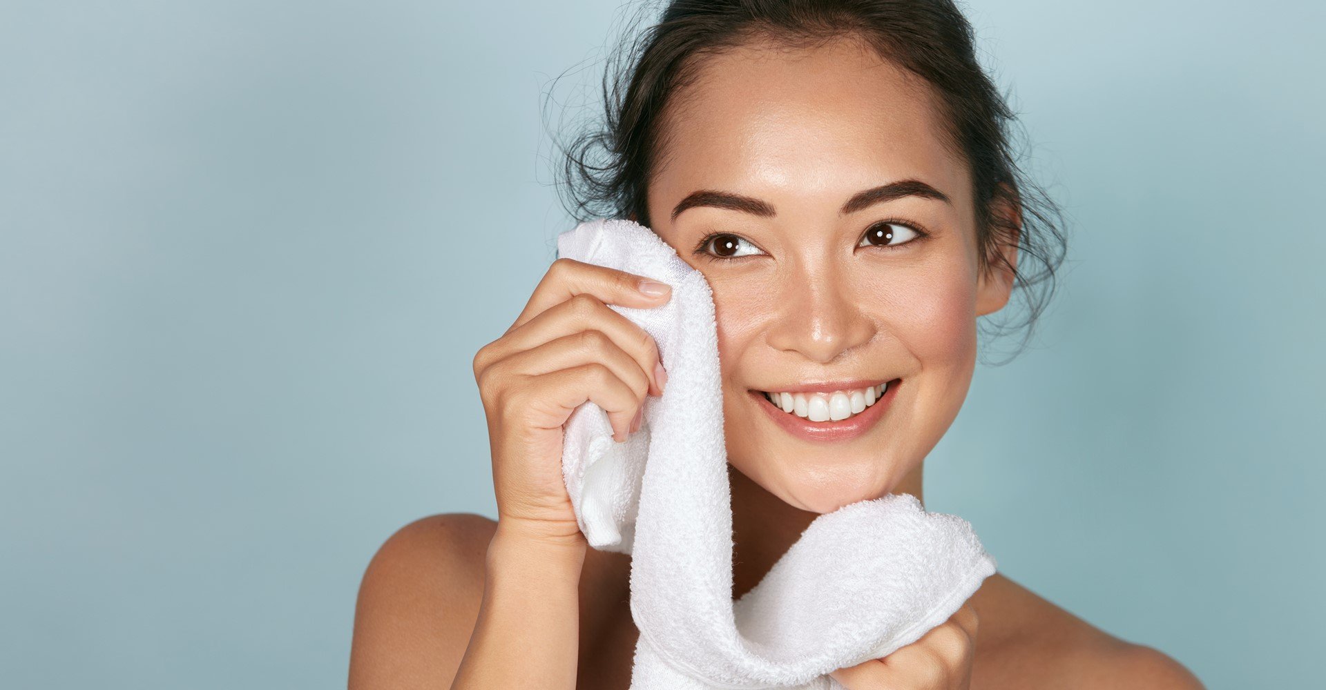 Modelo asiática sorrindo com toalha na mão