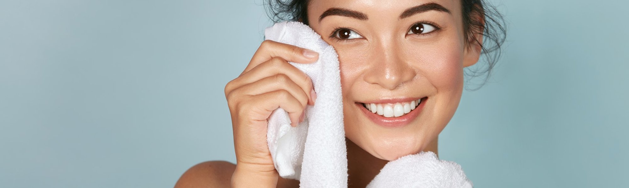Modelo asiática sorrindo com toalha na mão