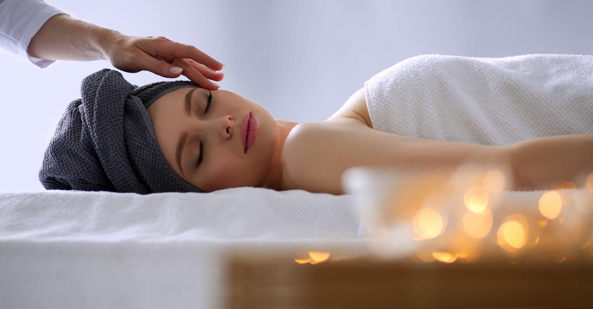 Modelo branca, deitada, com toalha na cabeça 