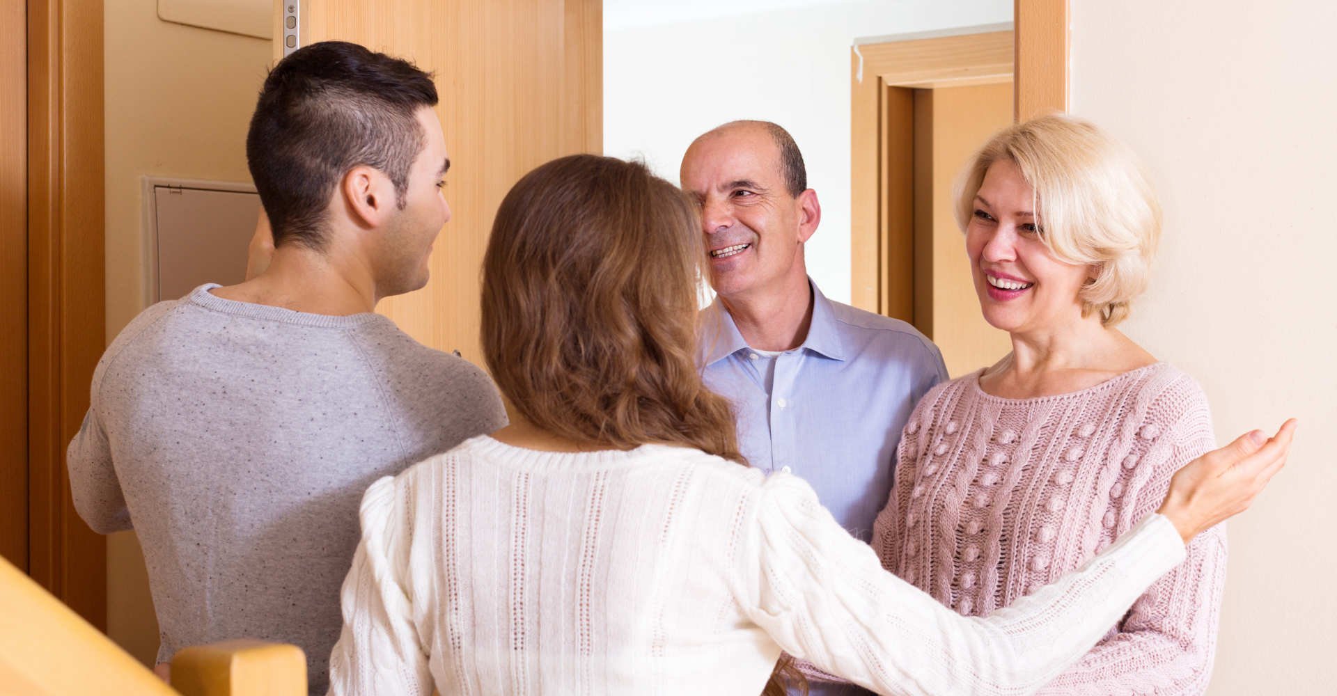 Imagem de quatro pessoas sorrindo e se cumprimentando