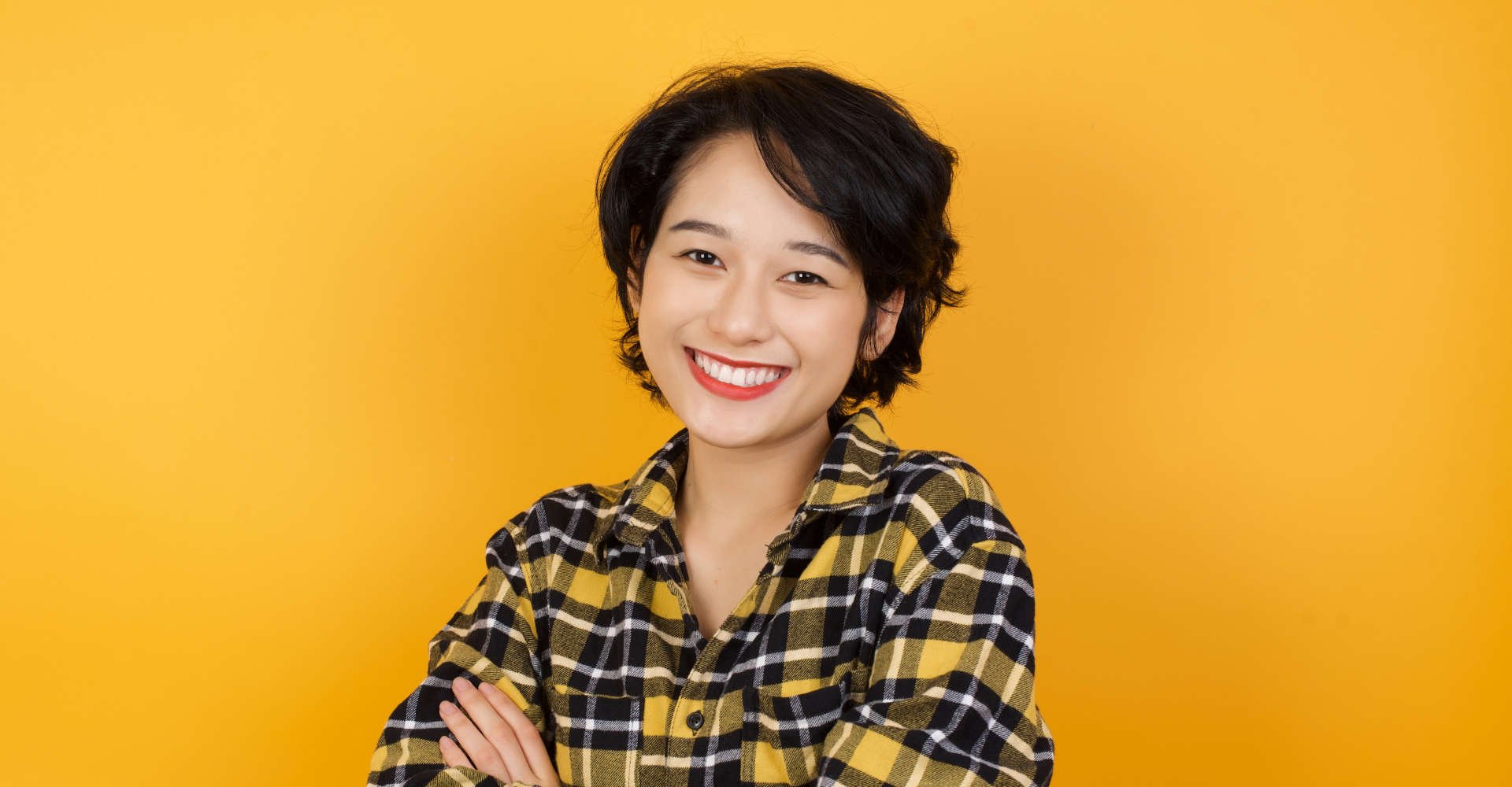 Modelo asiática com cabelo curso sorrindo para a foto