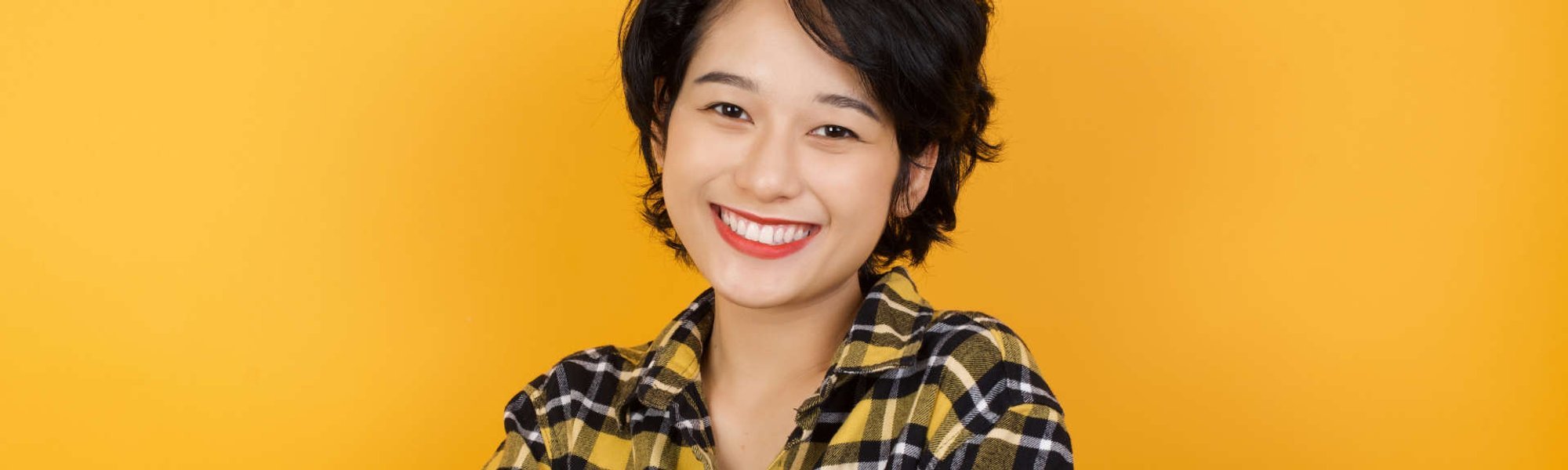 Modelo asiática com cabelo curso sorrindo para a foto