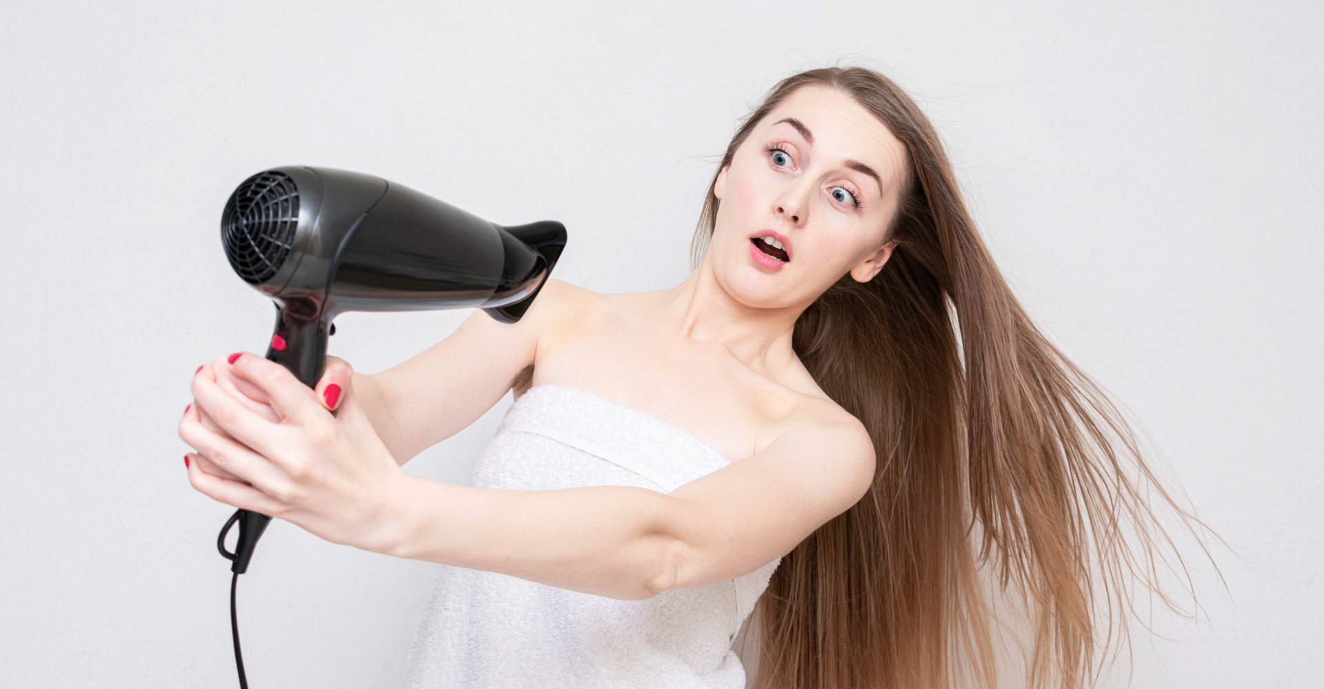 Modelo branca com cabelo liso segurando um secador