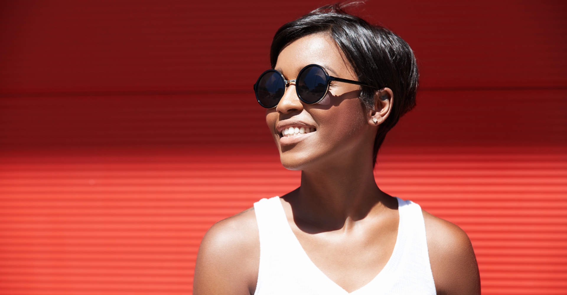 Modelo branca com cabelo curto preto e óculos de sol