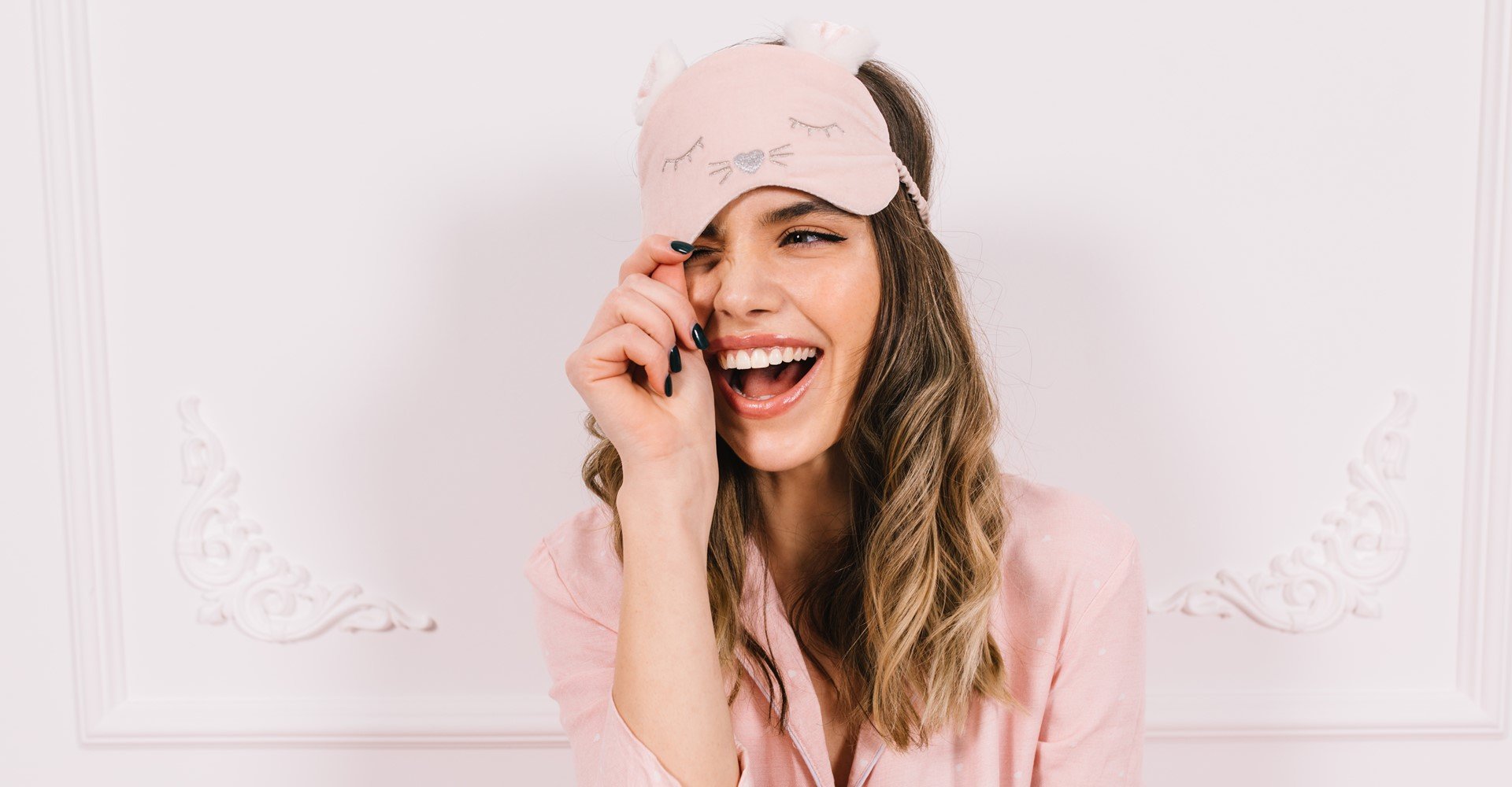 Modelo branca sorrindo com pijama rosa