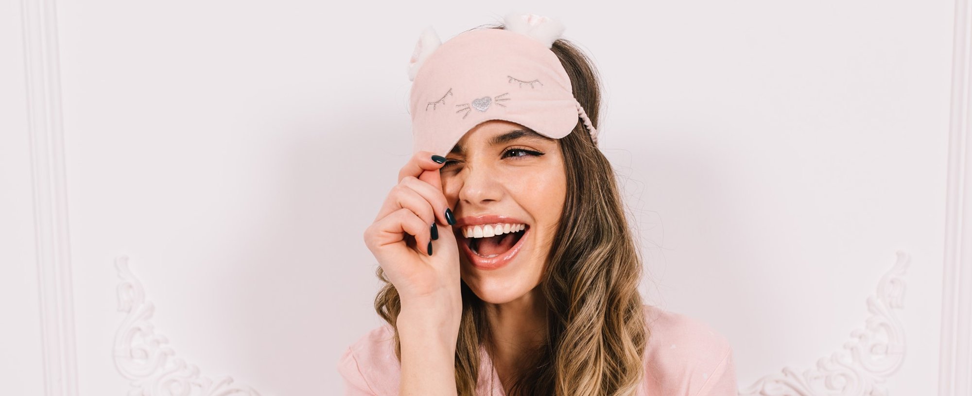 Modelo branca sorrindo com pijama rosa