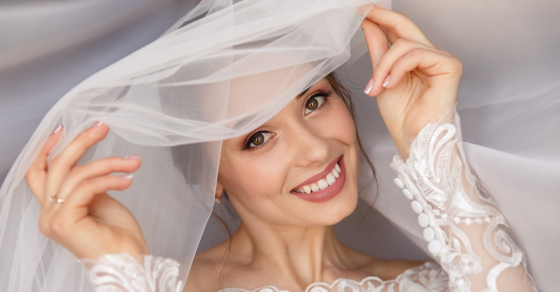 Modelo sorrindo com véu de noiva