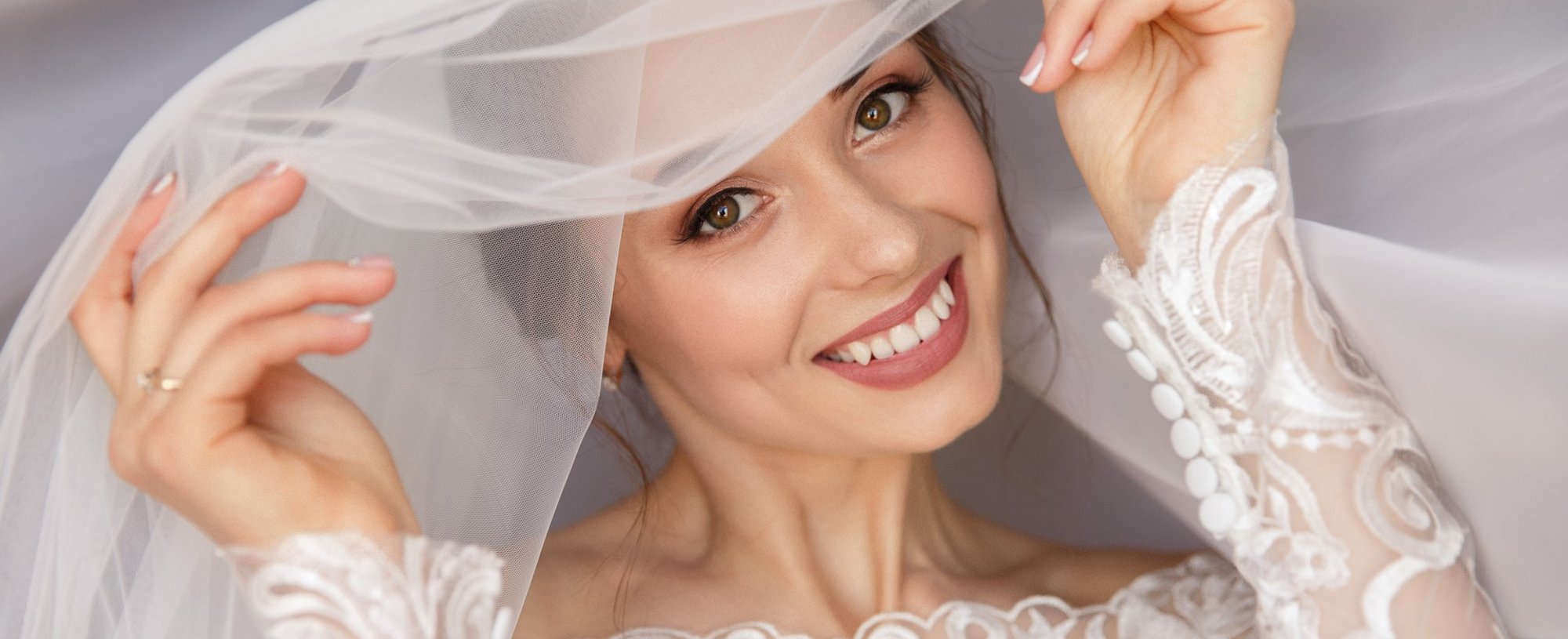 Modelo sorrindo com véu de noiva