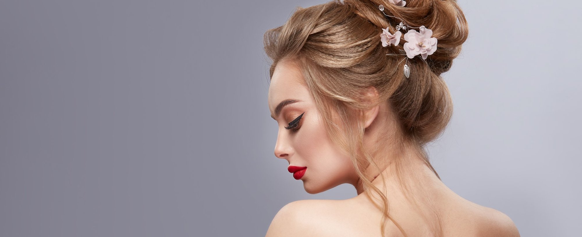 Modelo branca posando para a foto de costas com penteado coque de casamento