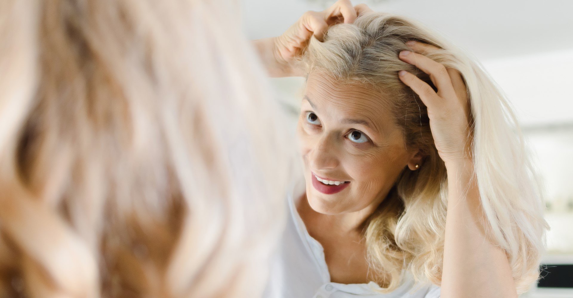 Modelo branca olhando seus fios brancos