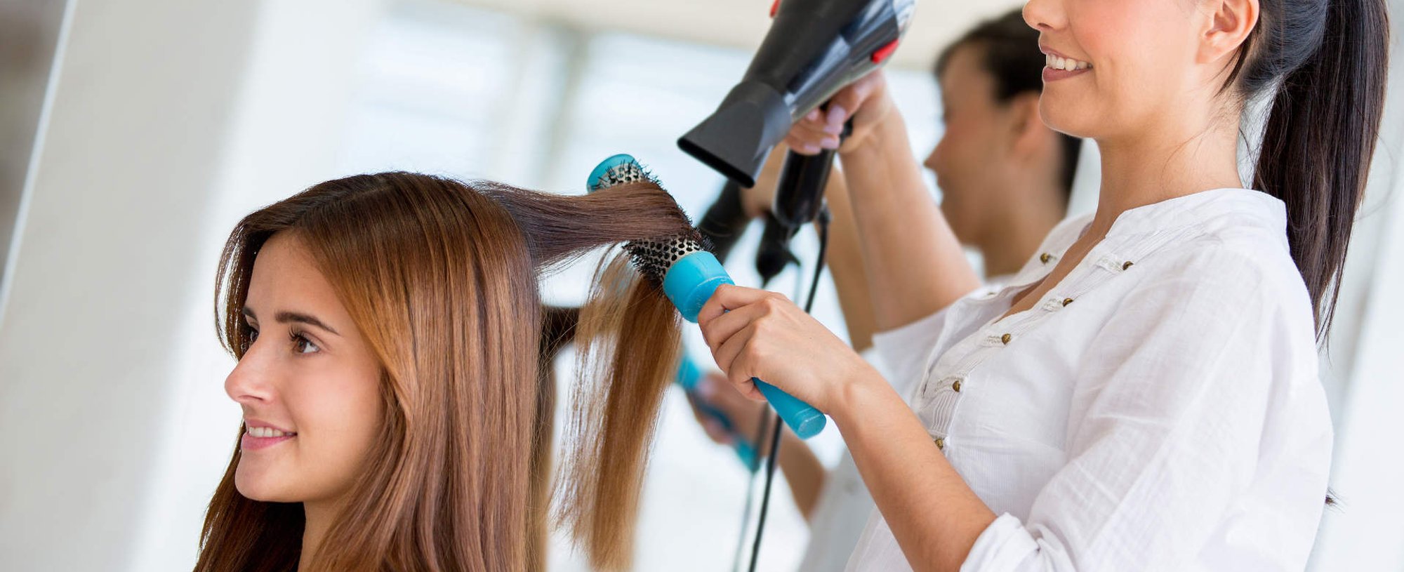 Profissionais com escova de cabelo e uma modelo com o cabelo liso
