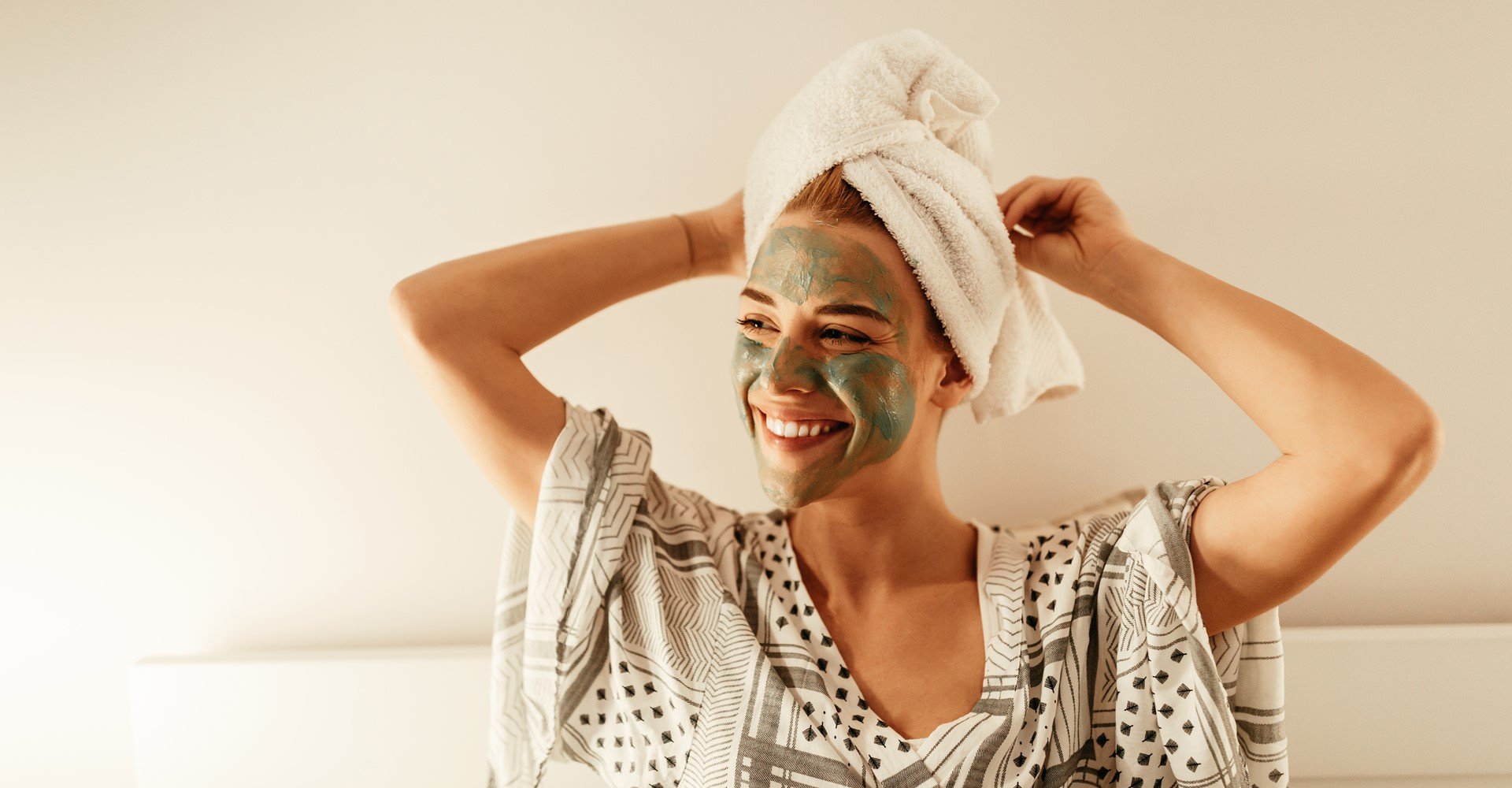 Modelo branca com toalha na cabeça e argila verde no rosto