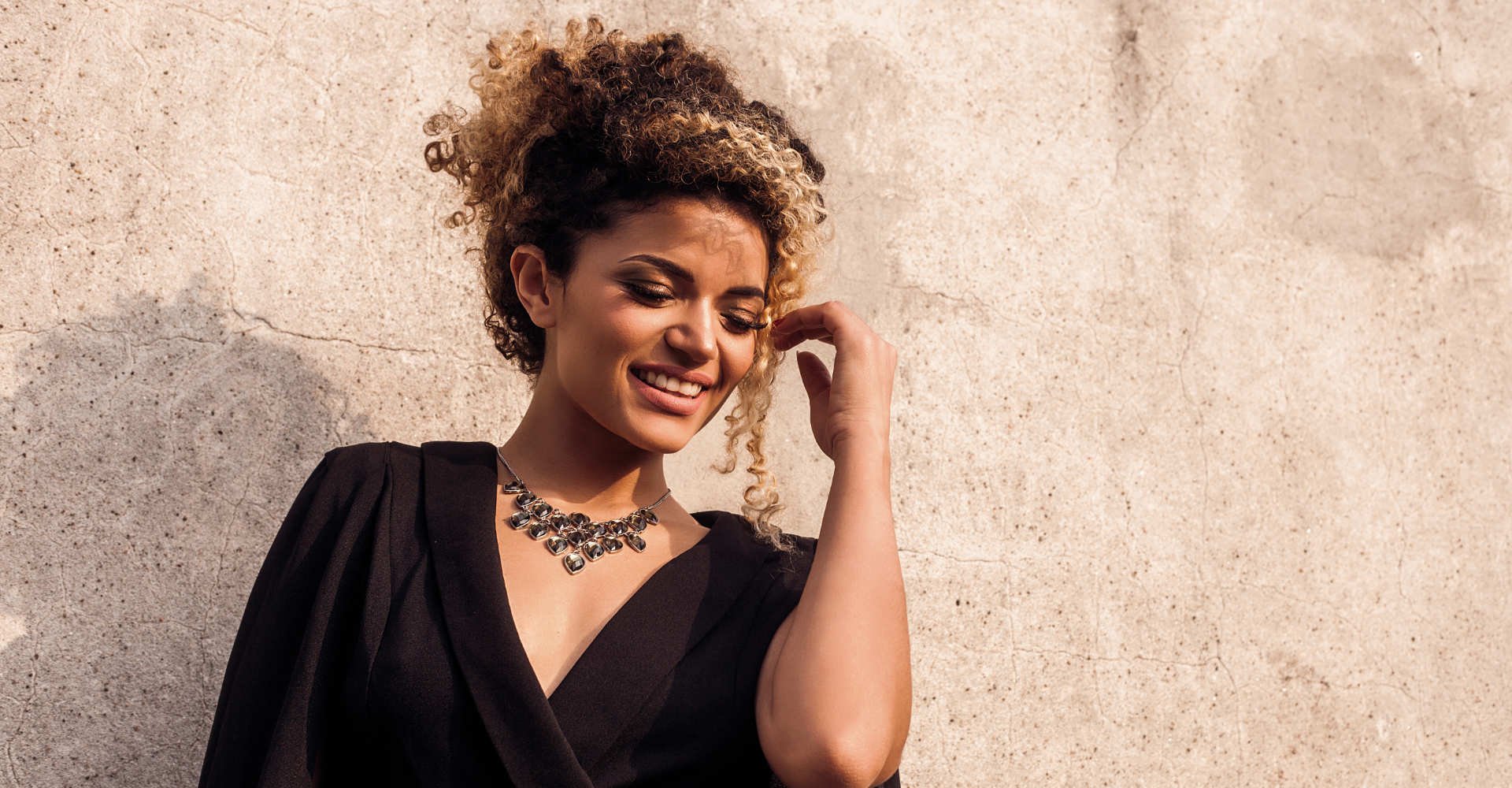 Modelo negra com cabelo cacheado e loiro