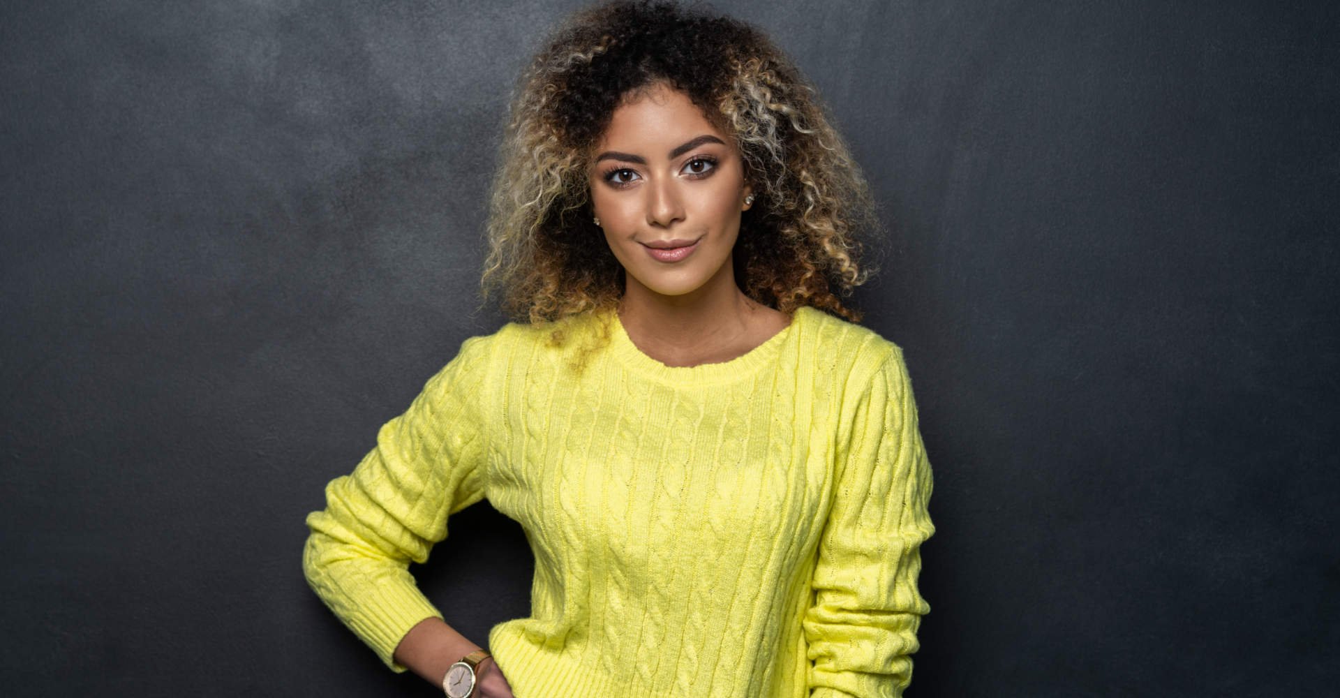 mulher exibe cabelos cacheados com coloração 