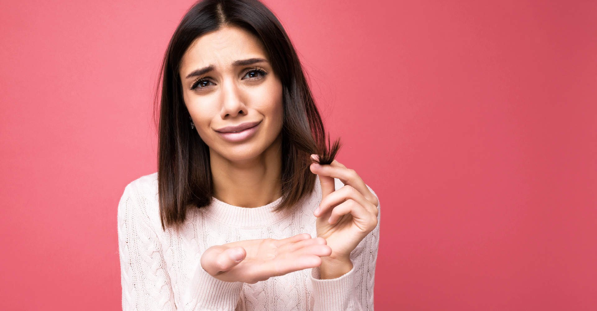 mulher insatisfeita segurando as pontas do cabelo