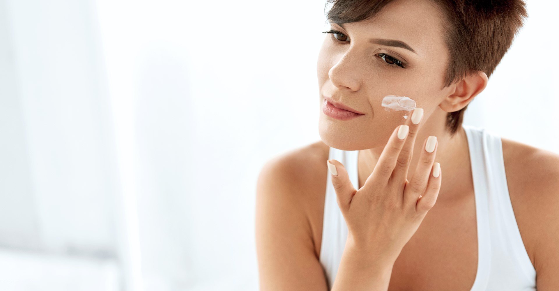 mulher passando creme no rosto