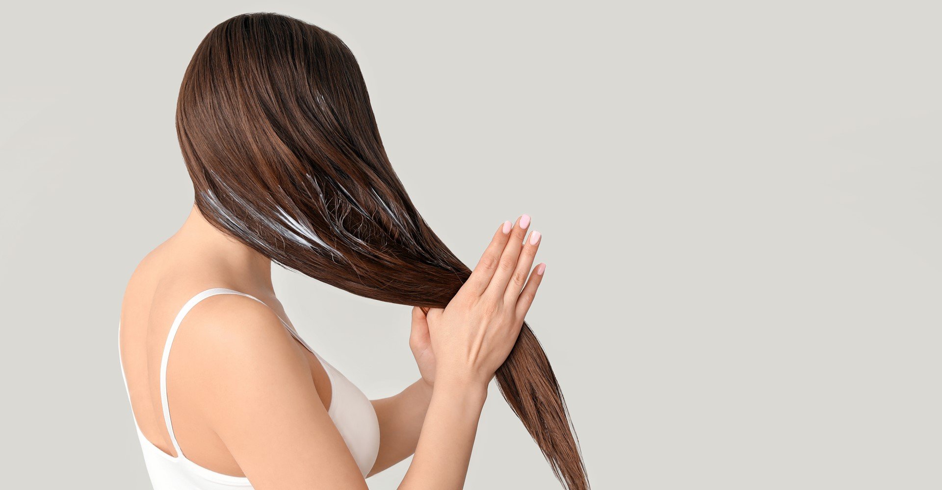 mulher passando creme em seus cabelos