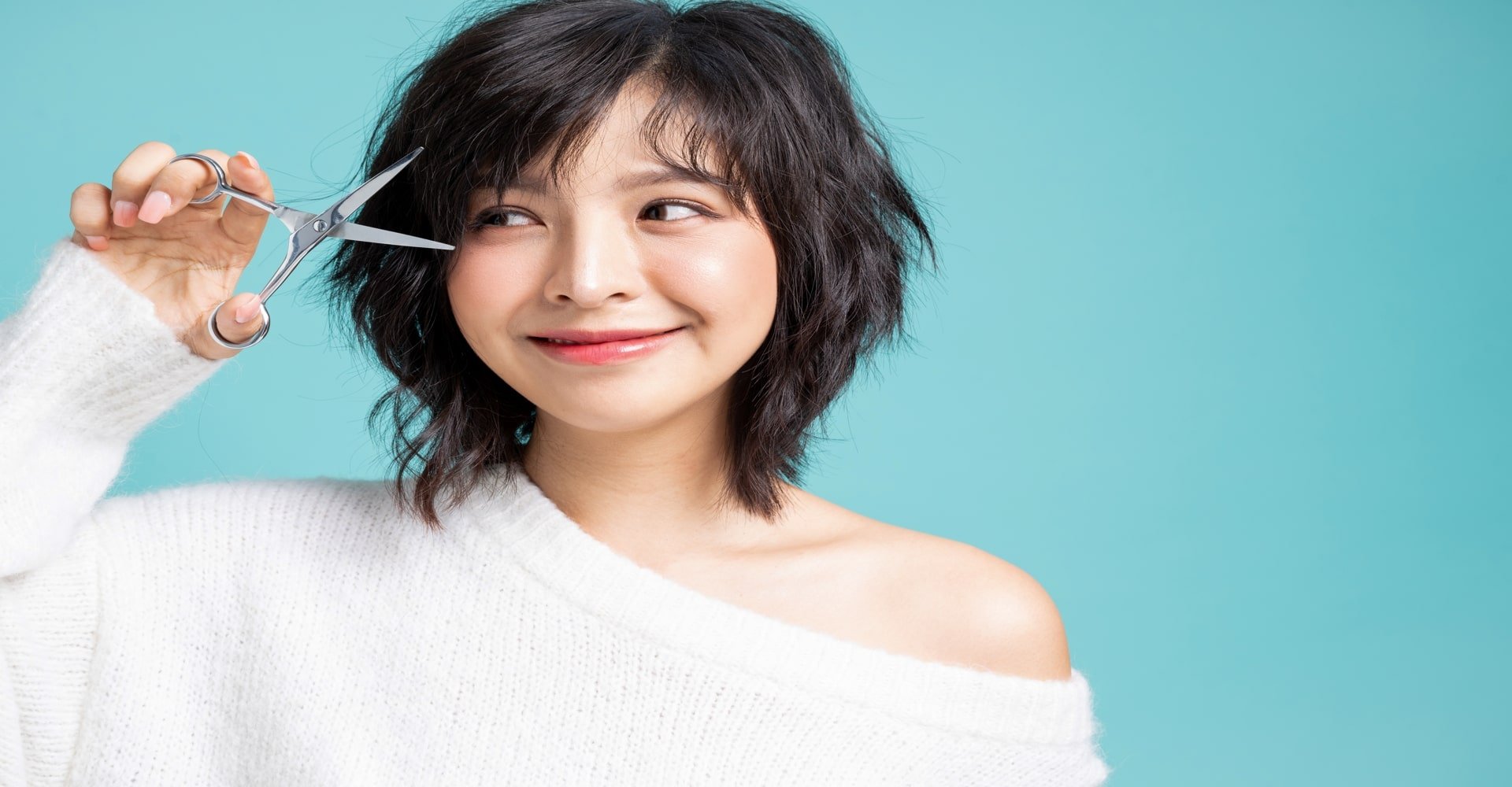 Modelo asiatica com tesoura na mao