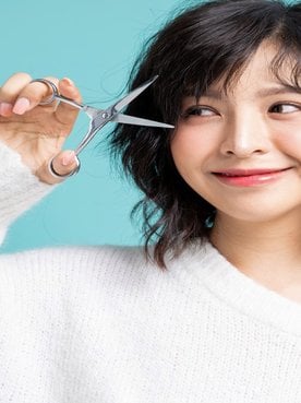 Modelo asiatica com tesoura na mao