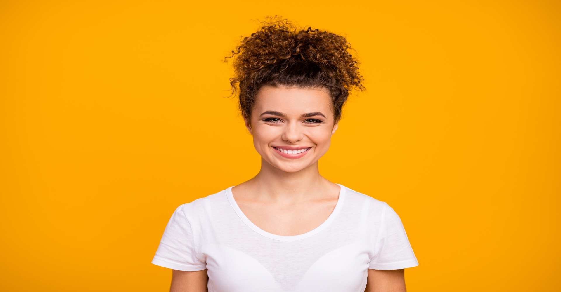 Modelo Branca Com Coque Em Seus Cabelos Cacheados