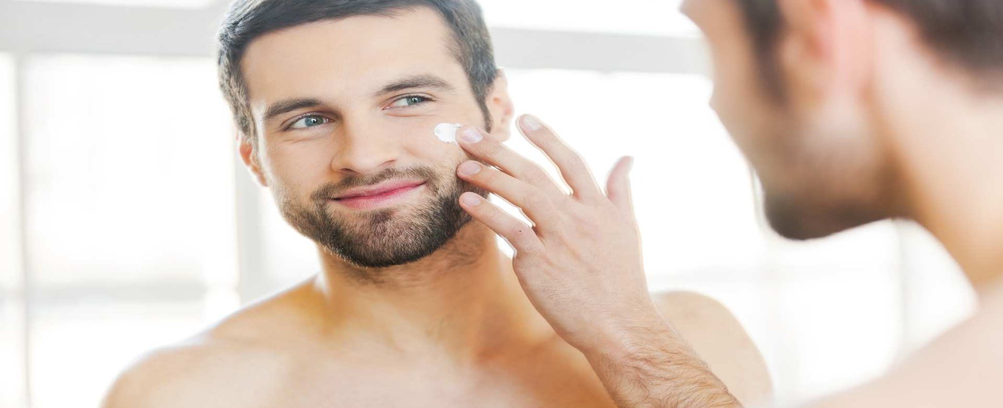 Modelo Branco Se Olhando No Espelho E Passando Creme No Rosto