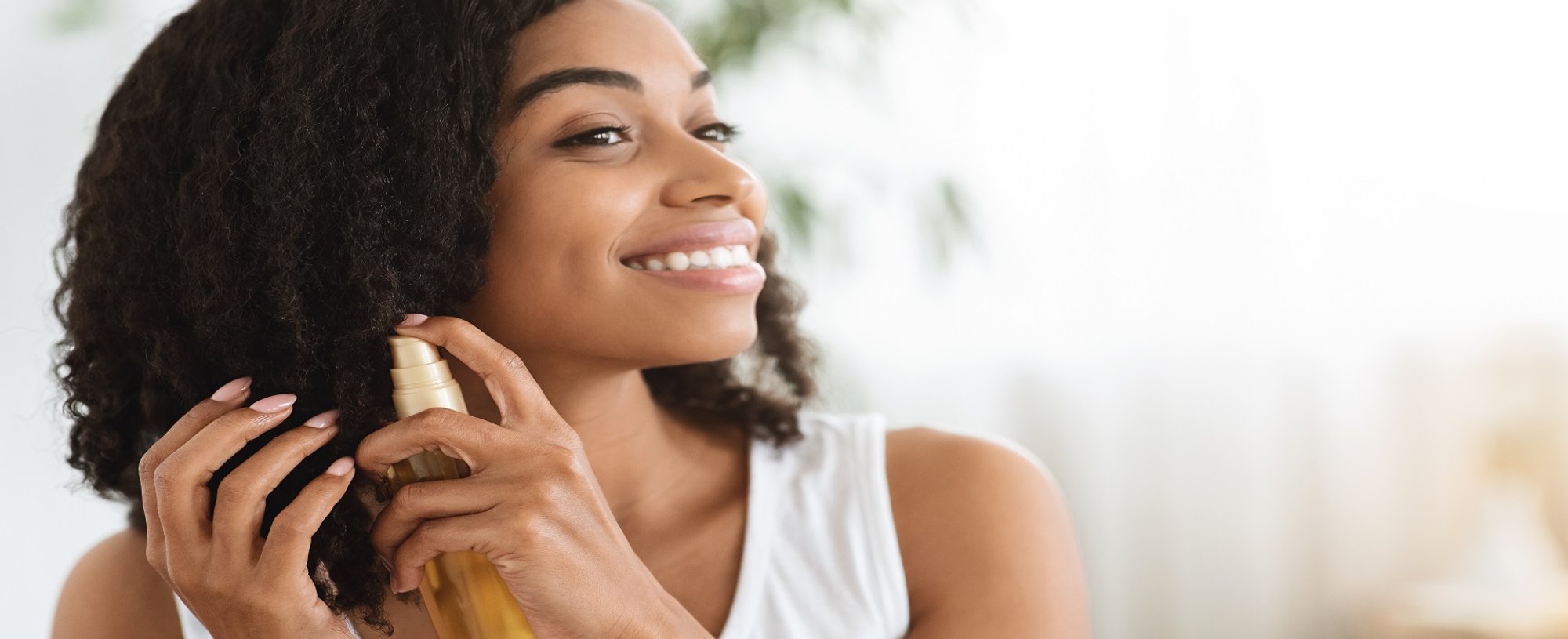 Modelo Negra Sorrindo E Passando Produto Em Seus Cachos