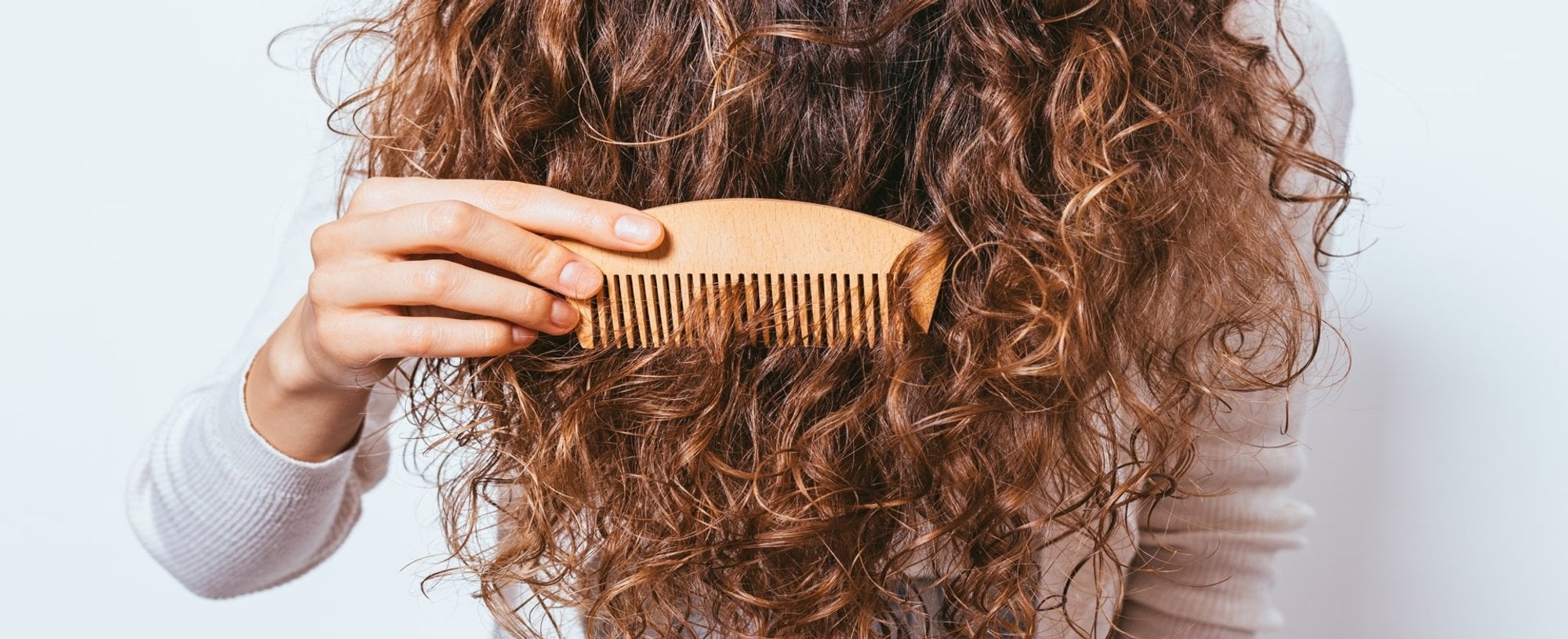 Modelo Passando Pente De Madeira Em Seu Cabelo Cacheado