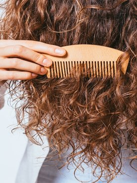 Modelo Passando Pente De Madeira Em Seu Cabelo Cacheado