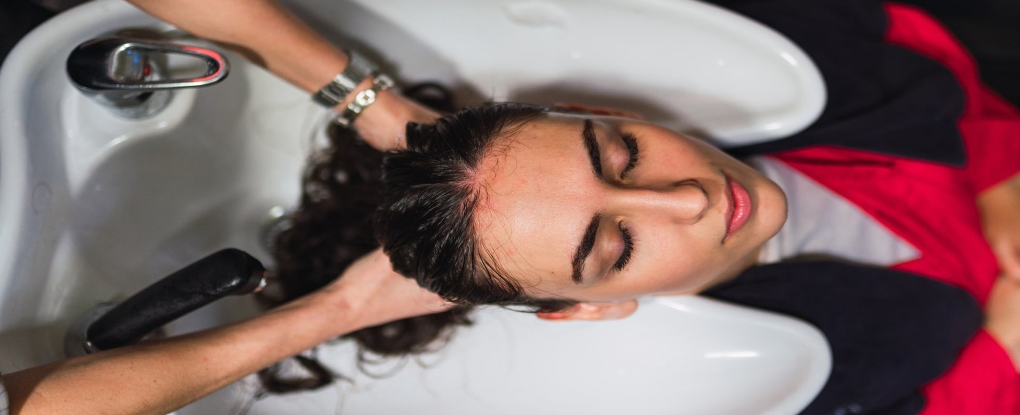 Profissional lavando o cabelo de modelo branca