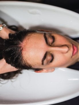 Profissional lavando o cabelo de modelo branca
