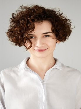 Modelo branca com o cabelo curto e cacheado