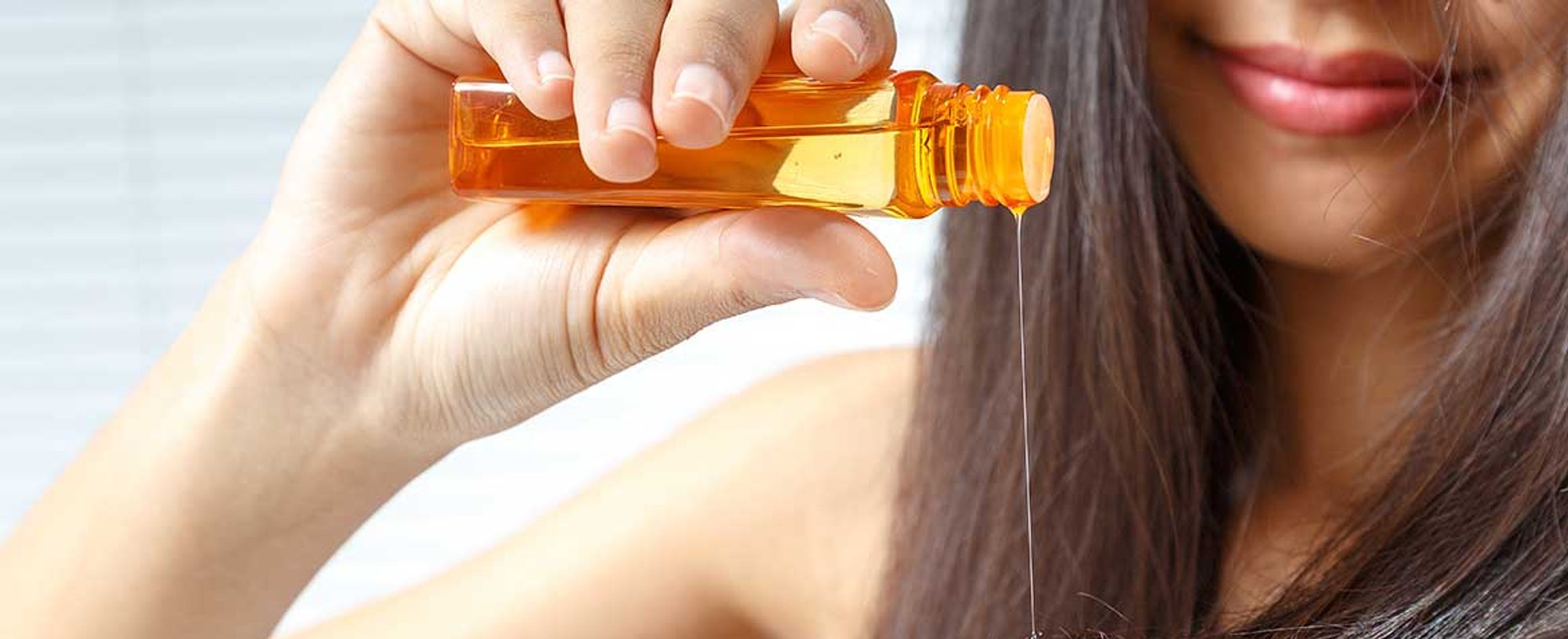 Mulher passando produto nas pontas do seu cabelo