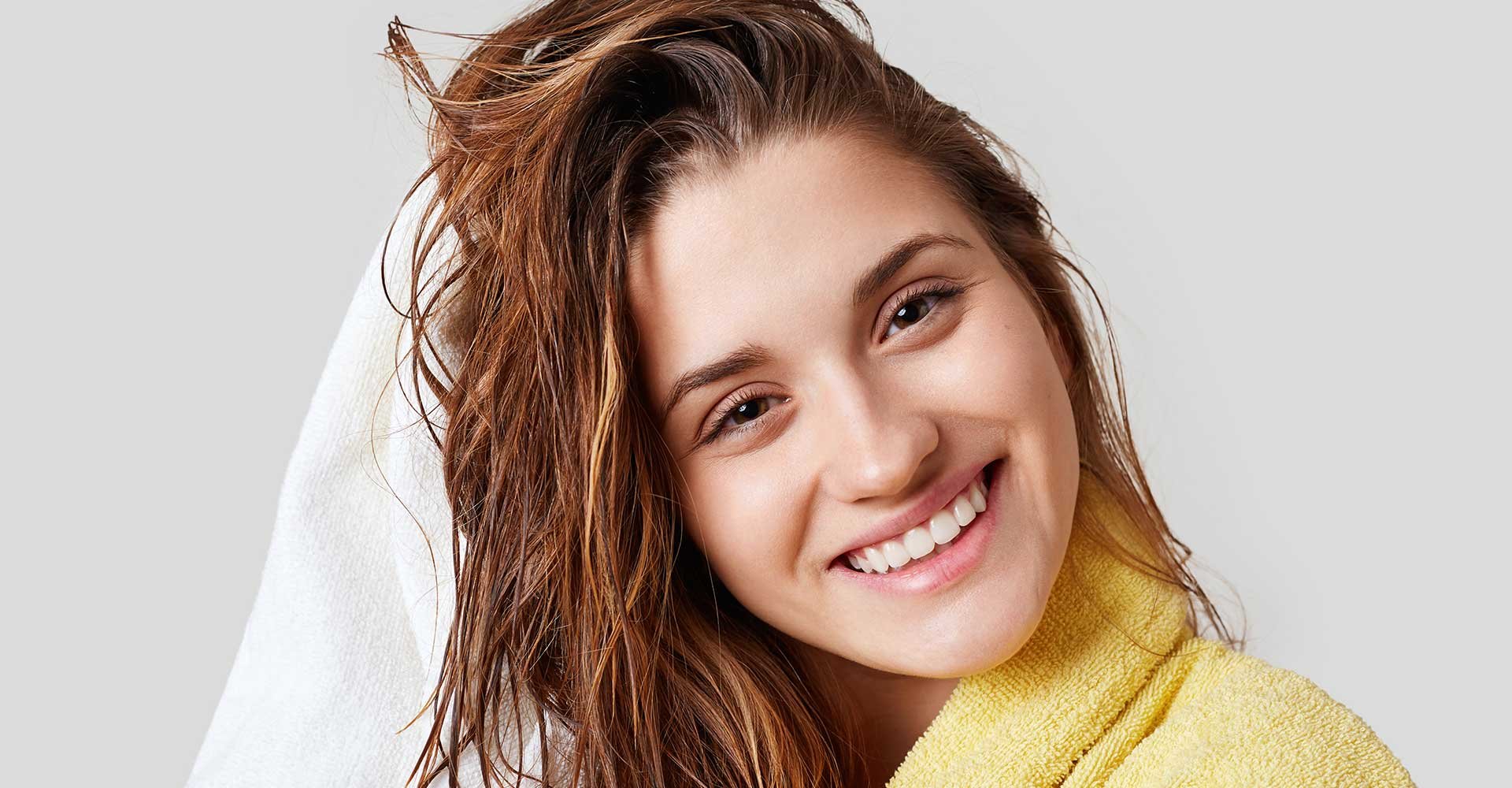 Mulher Secando O Cabelo E Sorrindo