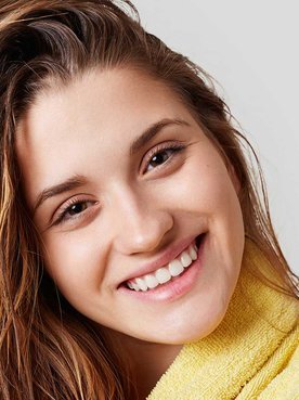 Mulher Secando O Cabelo E Sorrindo