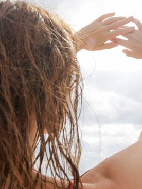 Modelo com cabelo molhado no sol