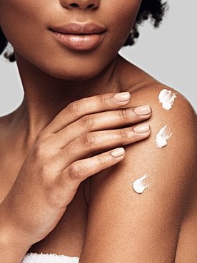 Modelo negra com creme no ombro