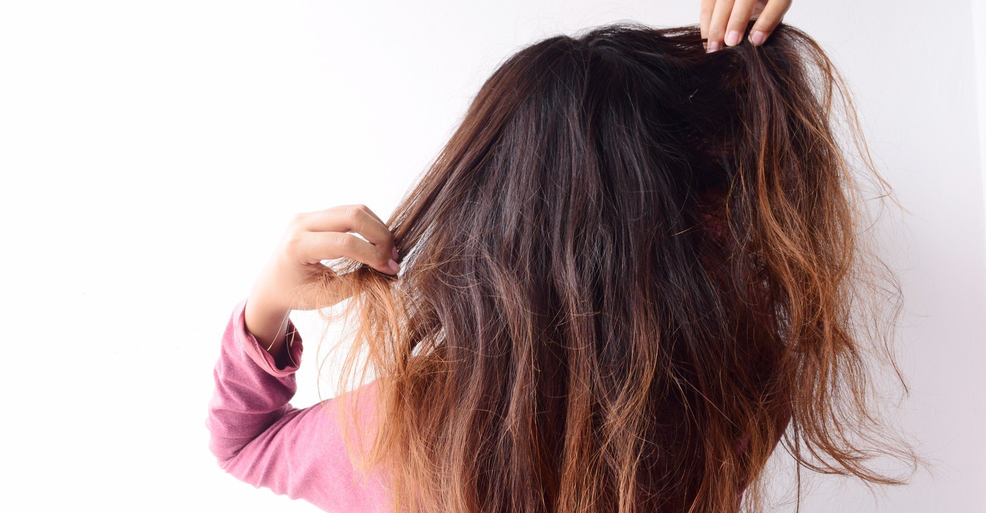 Modelo de costas mostrando seus cabelos danificados