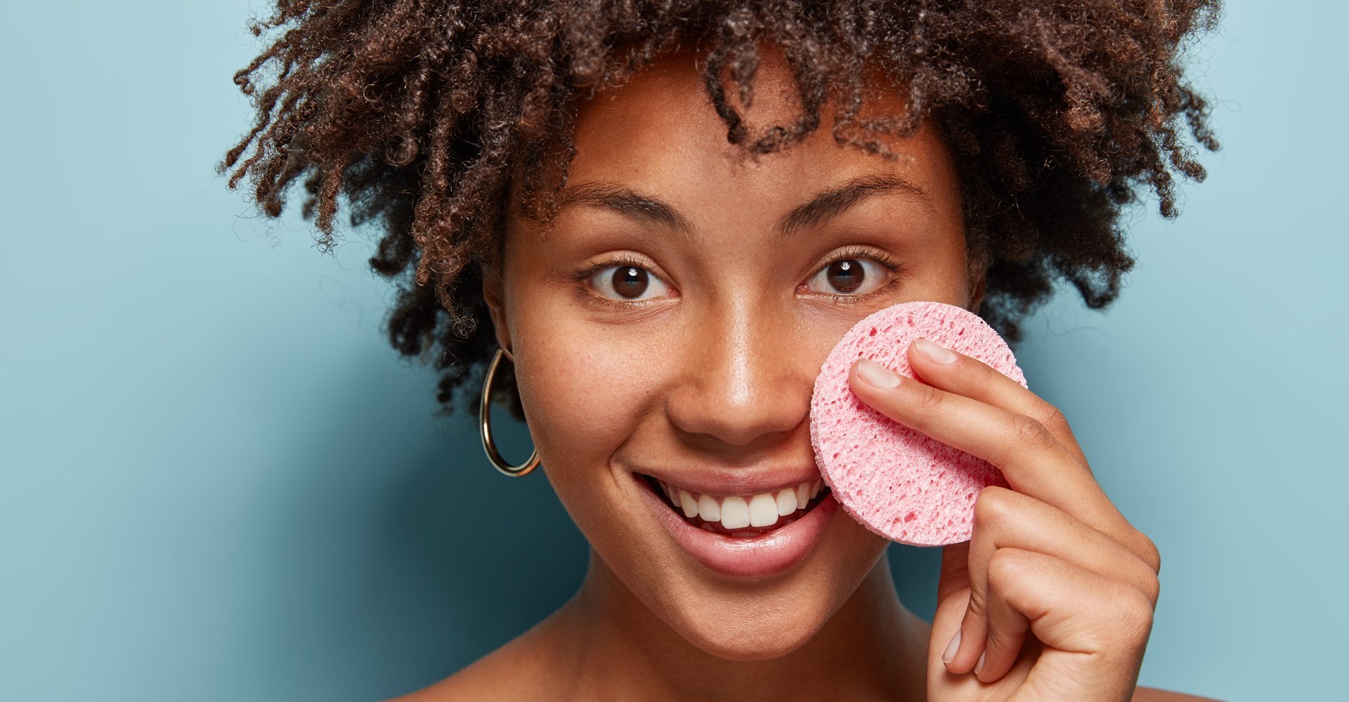 Modelo negra passando esponja no rosto