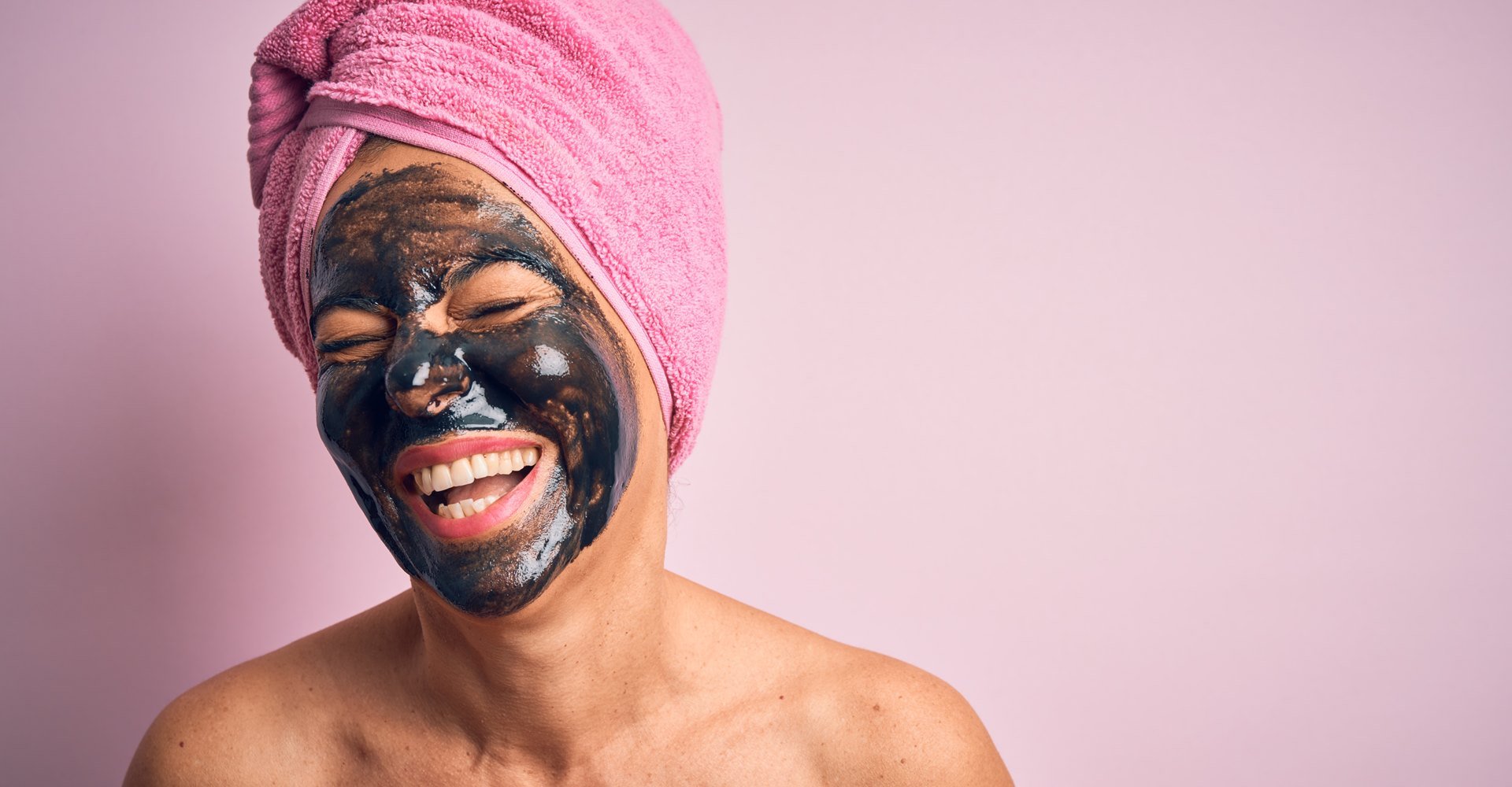 Modelo sorrindo com máscara preta no rosto