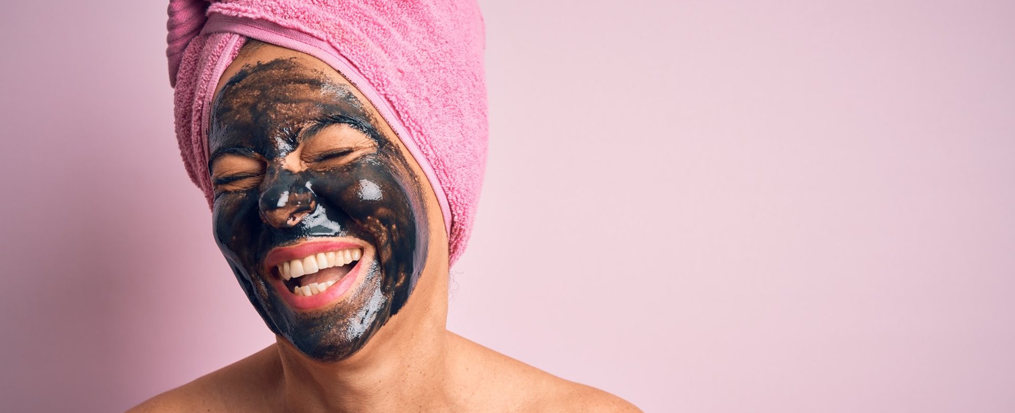 Modelo sorrindo com máscara preta no rosto