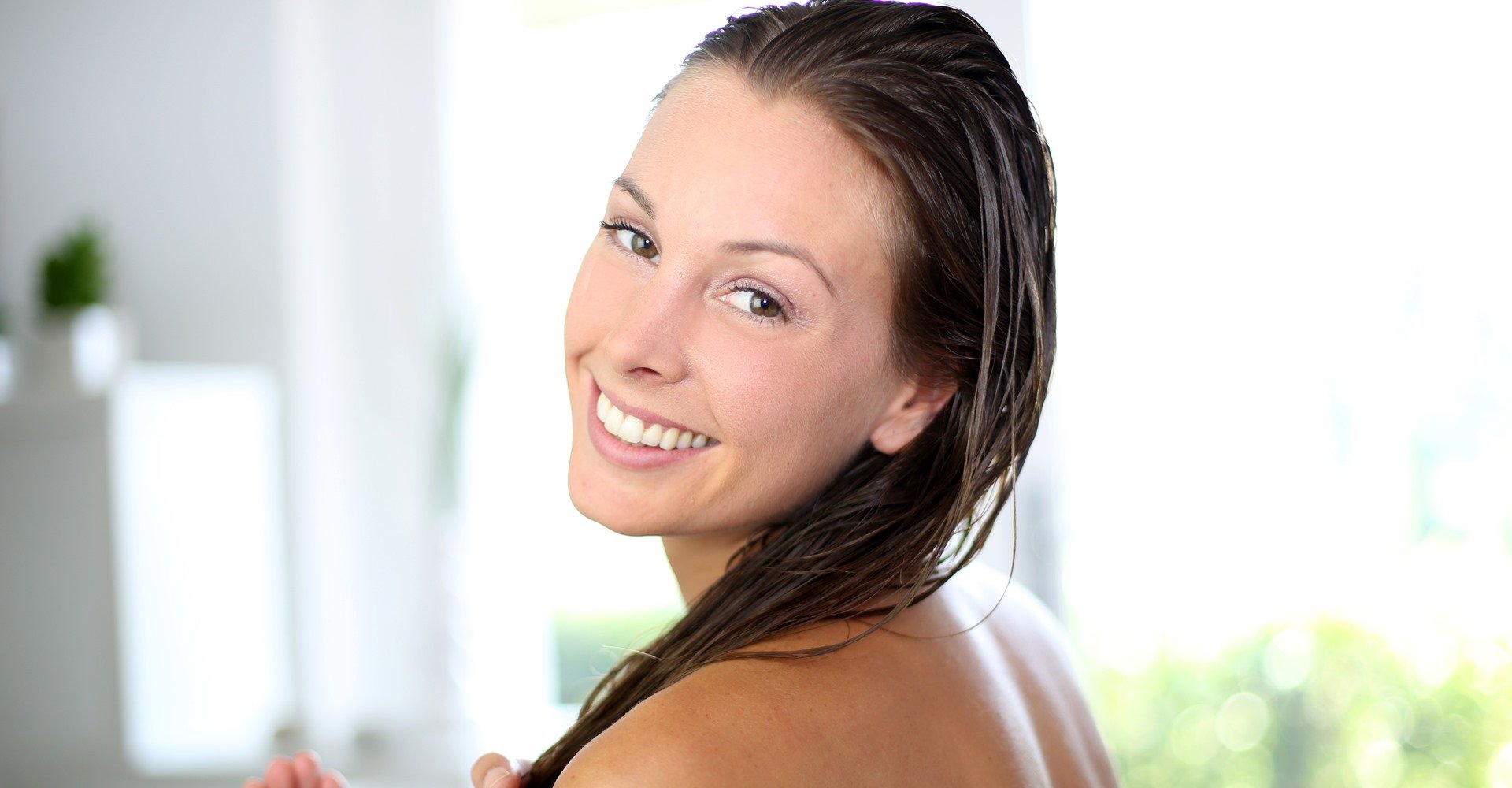 Mulher Sorrindo Enquanto Passa Condicionador No Seu Cabelo