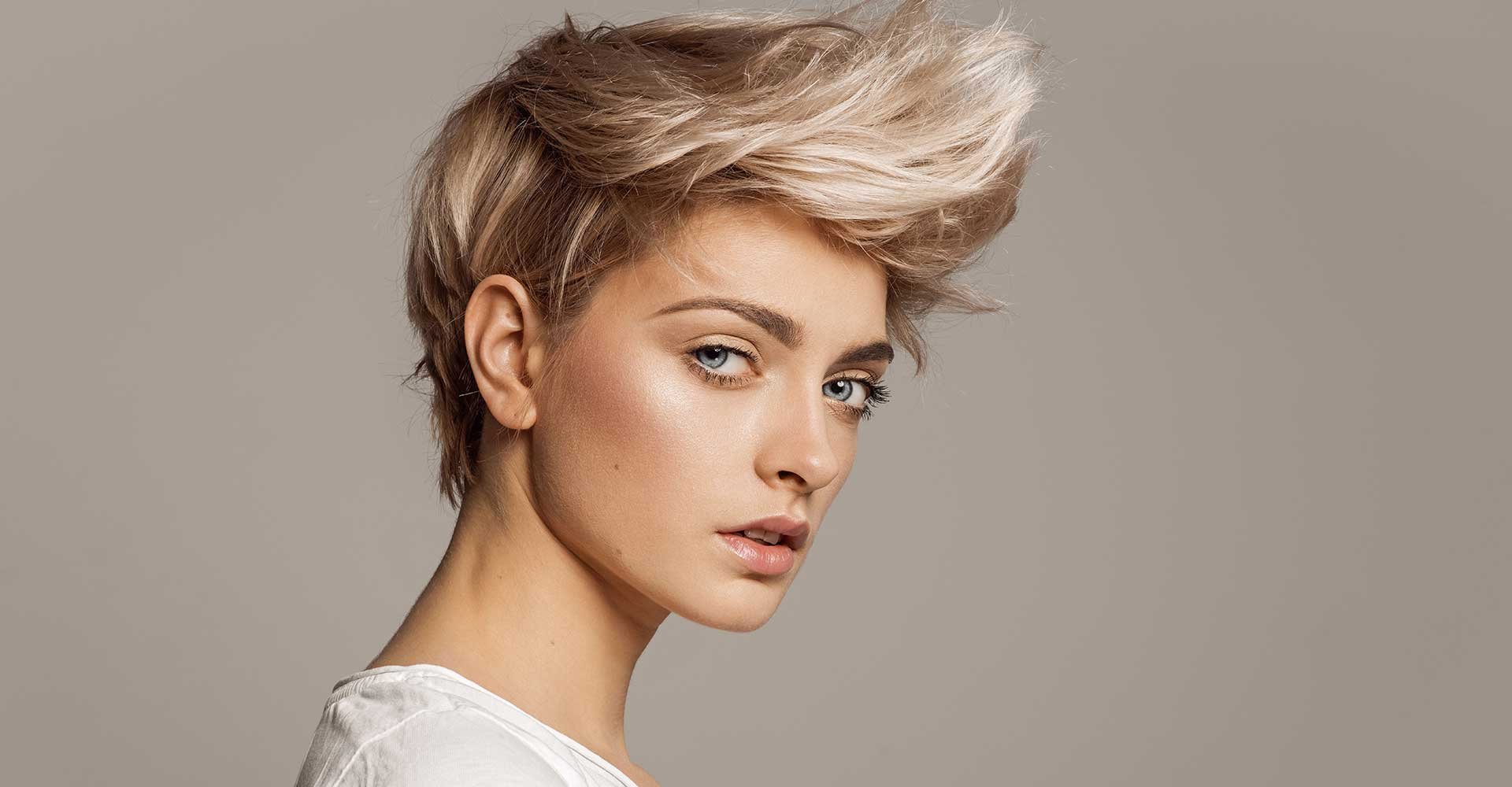 Modelo loira com cabelo curto e um topete curvado para cima