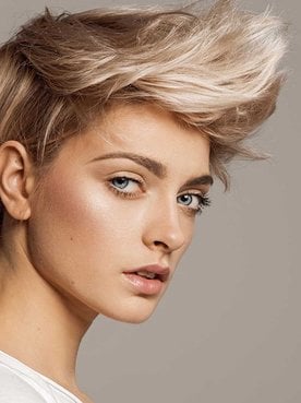 Modelo loira com cabelo curto e um topete curvado para cima