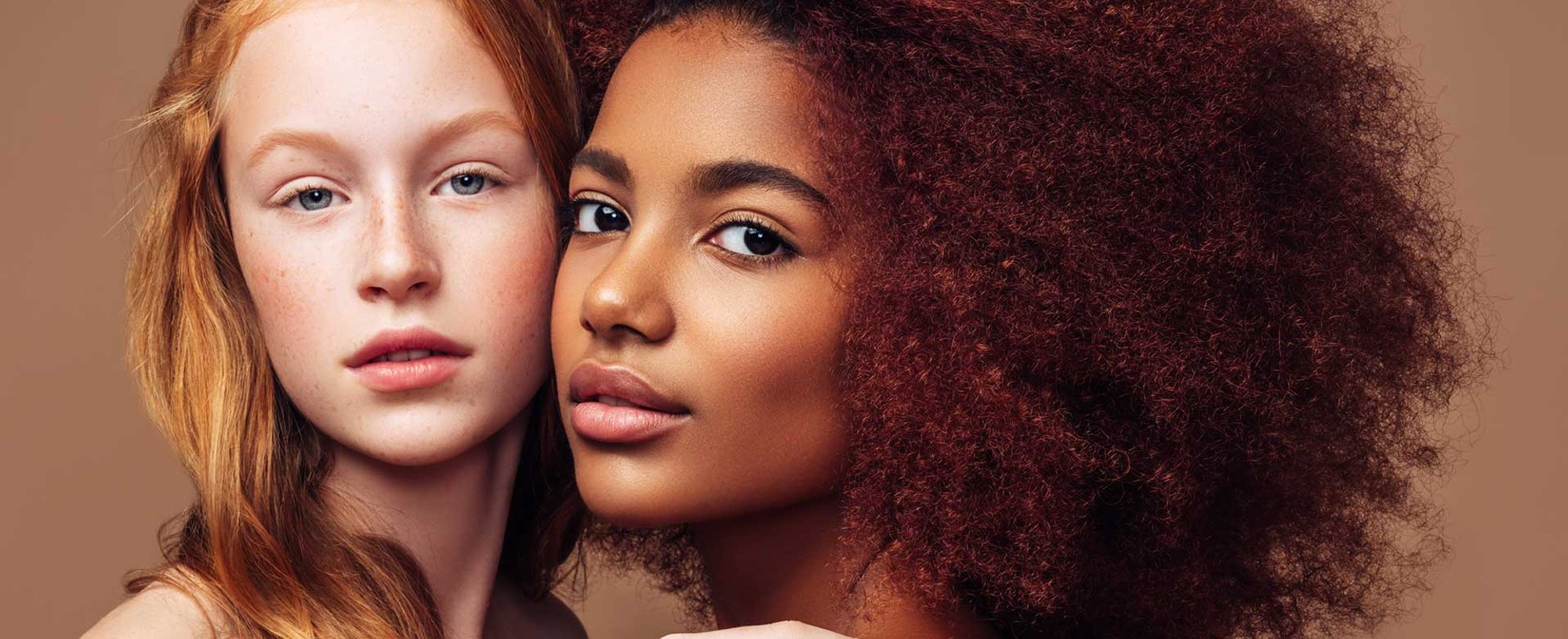 Dupla De Modelos Uma Ruiva Com Cabelo Liso E Outra Negra Com Volumosos Cabelos