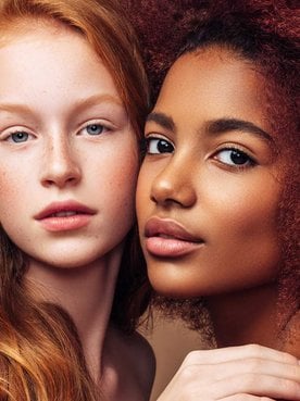 Dupla De Modelos Uma Ruiva Com Cabelo Liso E Outra Negra Com Volumosos Cabelos