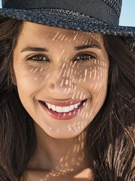 Modelo branca na praia com chapéu preto