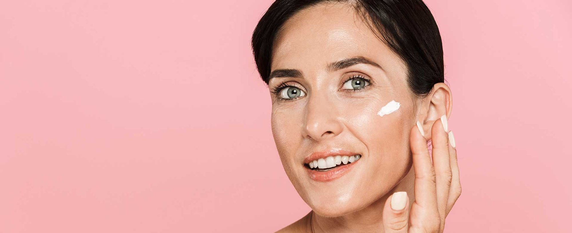 Mulher passando protetor solar em seu rosto