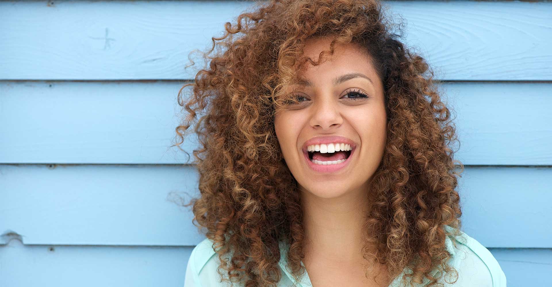 Mulher sorrindo com cabelos castanhos claro